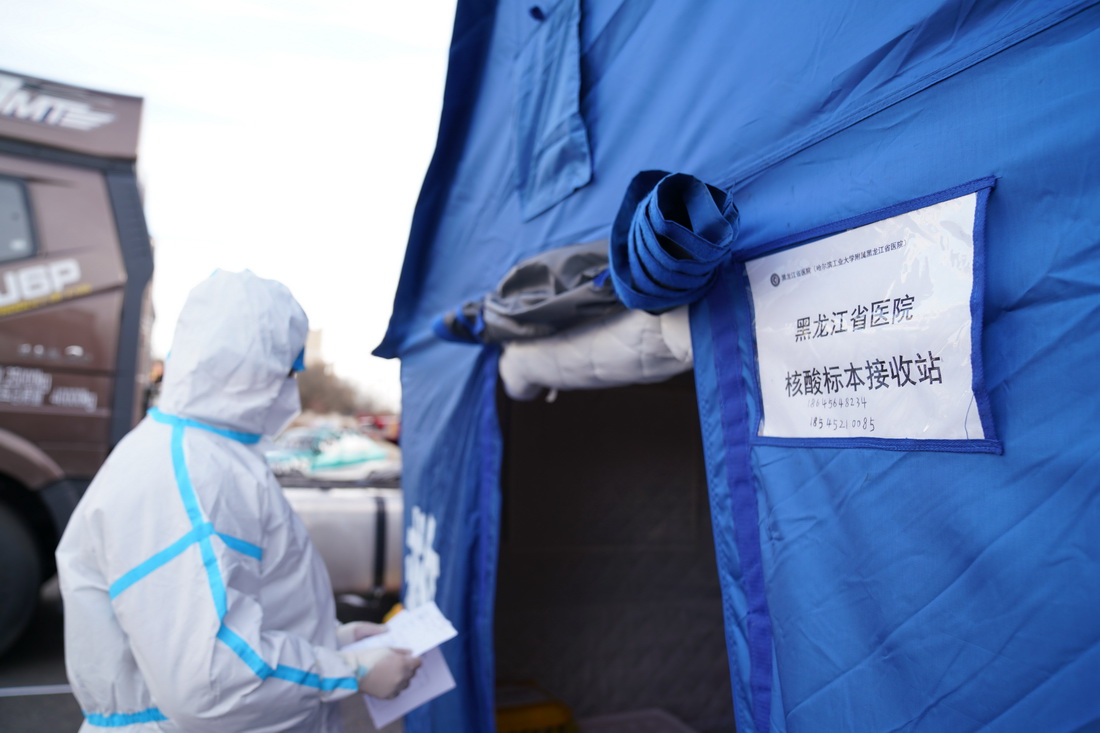 11月15日，在黑龙江省黑河市爱辉区，医务人员在交接核酸标本。
