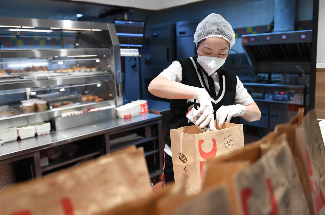 1月13日，在西安市一家连锁餐厅，工作人员打包外卖。