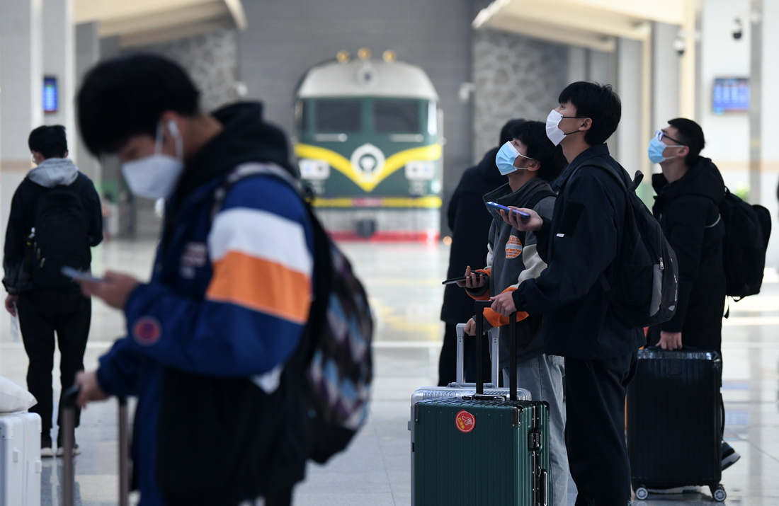 1月17日，高校学生在西安站候车大厅查看列车信息。