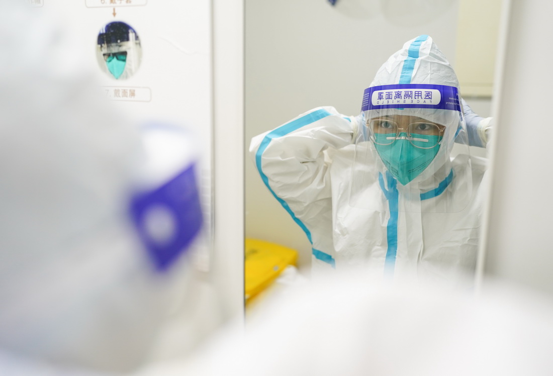 3月23日凌晨，核酸检测实验室的工作人员吕文航在穿戴防护面罩。