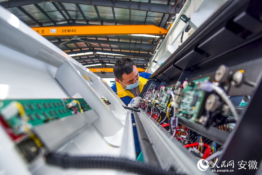 安徽中科光电色选机械有限公司的工人正在进行设备最终组装调试。人民网 李希蒙摄