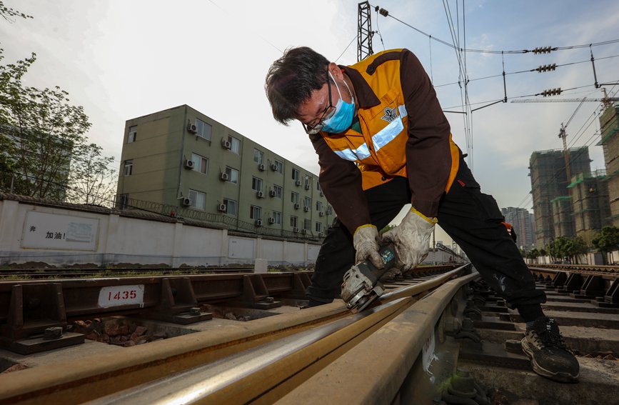 2022年4月9日，河南郑州，京广铁路第一阶段集中修施工现场，作业人员手工打磨道岔设备。 宛文鹏摄