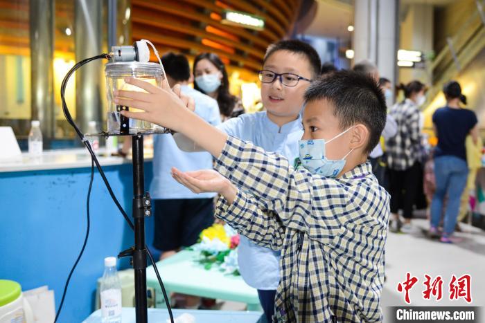 活动现场一位小朋友在展示他的创新发明——酒精消毒机。　何蓬磊 摄