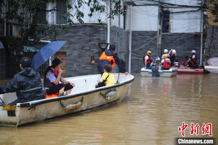民警乘坐小舟帮助被洪水围困的市民。　蒙鸣明 摄