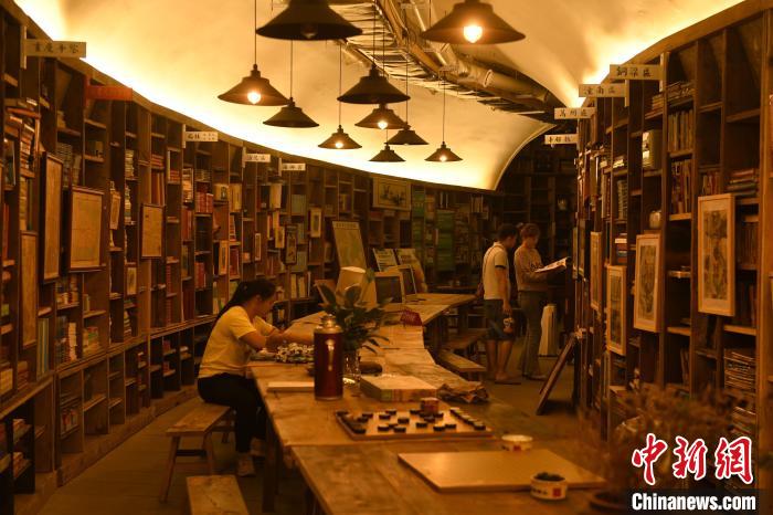 图为市民在防空洞改造的书屋内看书学习。　周毅 摄