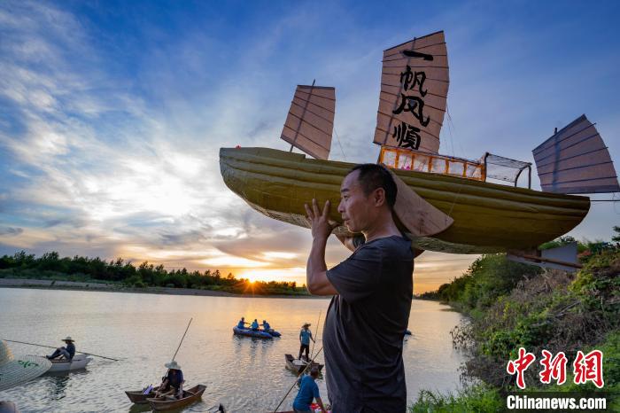 在安徽省宣城市宣州区水东古镇水阳江畔，村民扛着船模，祈盼来年风调雨顺。　李晓红 摄