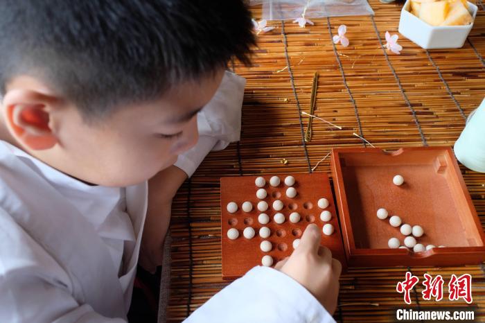 一名男孩正在玩”孔明棋“。　刘俊聪 摄