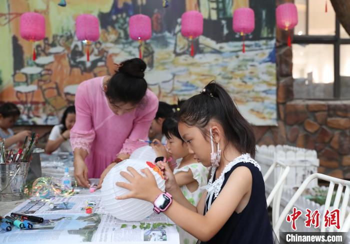小朋友在宁夏银川市贺兰山天籁艺术村体验彩绘灯笼。　于晶 摄
