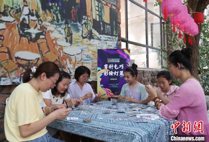 市民在宁夏银川市贺兰山天籁艺术村体验穿针乞巧。　于晶 摄