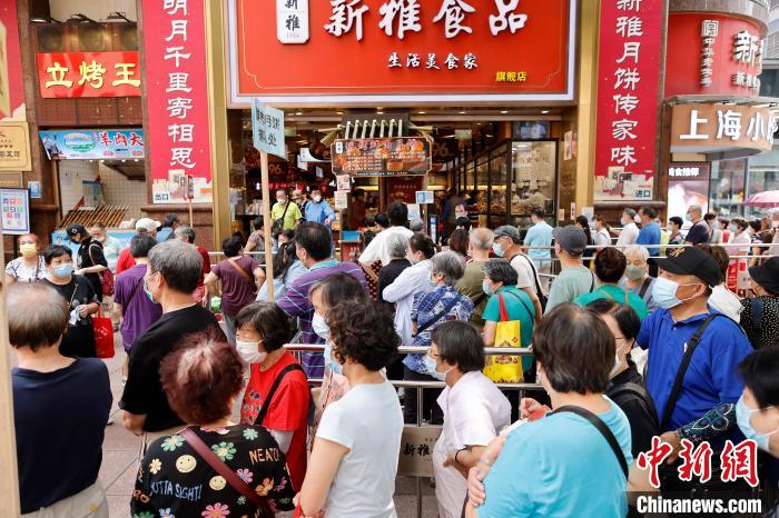 民众在上海南京东路步行街上排队购买月饼。　殷立勤 摄