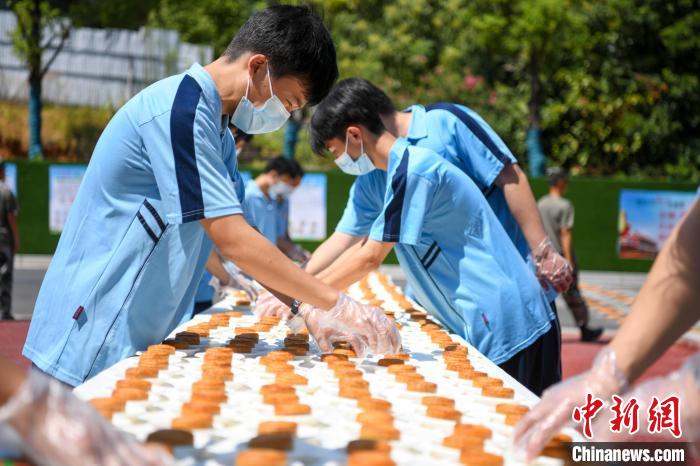 辣条专业班的学生将1000个辣条月饼摆放在校内食堂门口。　杨华峰 摄