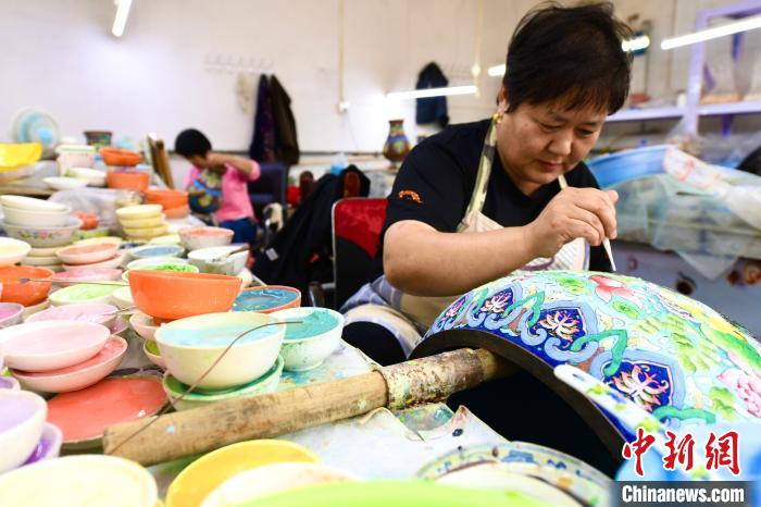 大厂回族自治县邵府村一景泰蓝创新工作室，女工正在为景泰蓝工艺品“点蓝”上色。