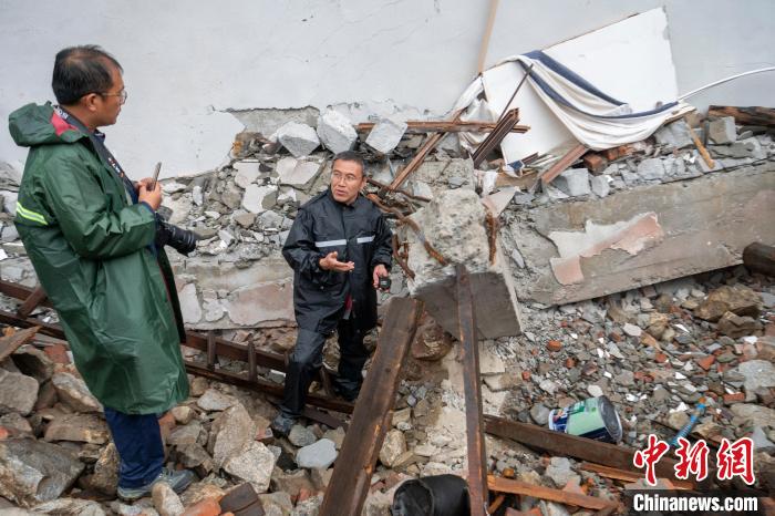 戴君武(右)考察地震中垮塌的房屋。　刘忠俊 摄