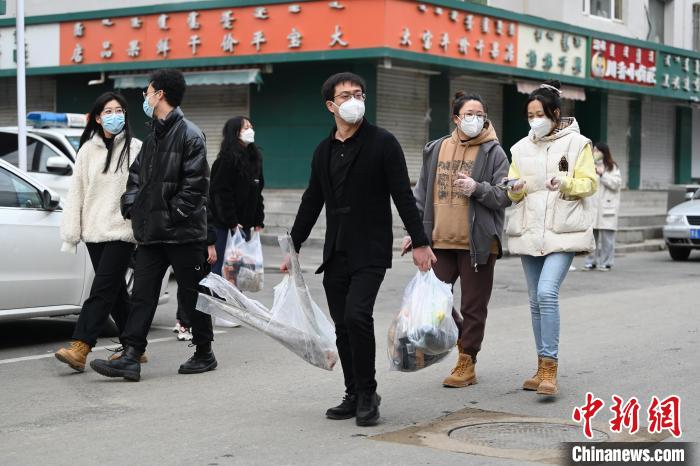 11月20日，内蒙古呼和浩特市，一位男士双手提着满载的购物袋。　刘文华 摄