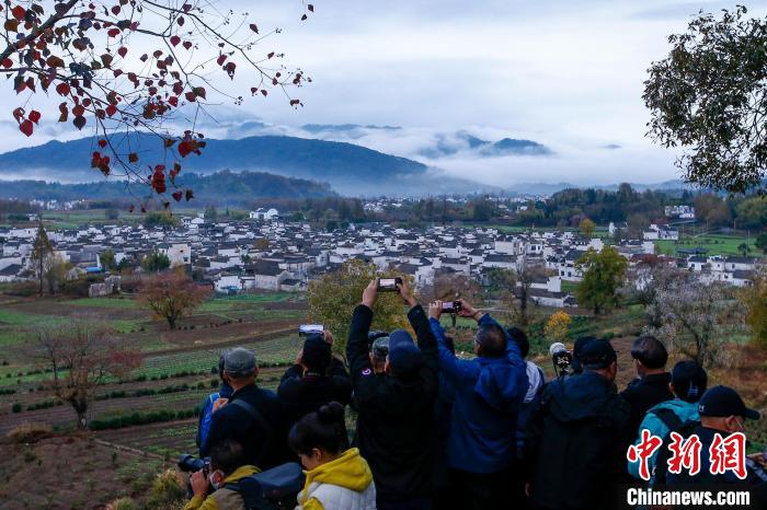 游客在安徽省黄山市黟县宏村镇卢村欣赏雨后美景。　施亚磊 摄