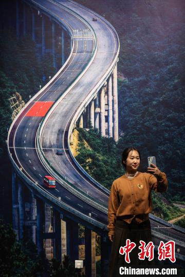 参观者在“这样的贵州”主展厅“贵州高速公路”摄影作品前自拍。　瞿宏伦 摄