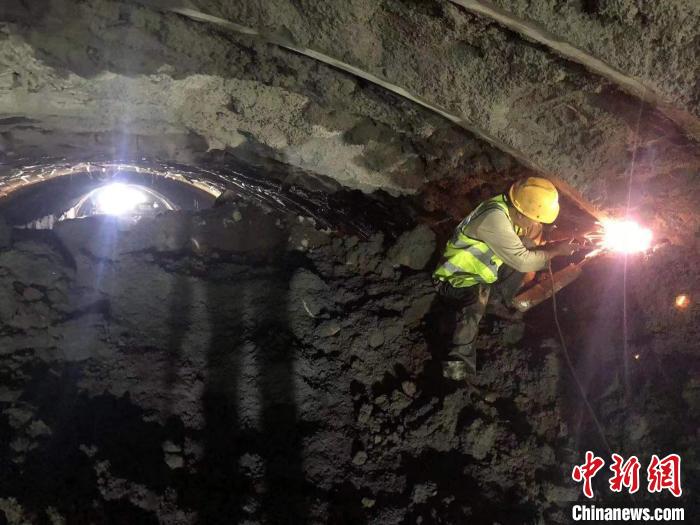 图为工人在坡脚隧道内施工。　李昆 摄