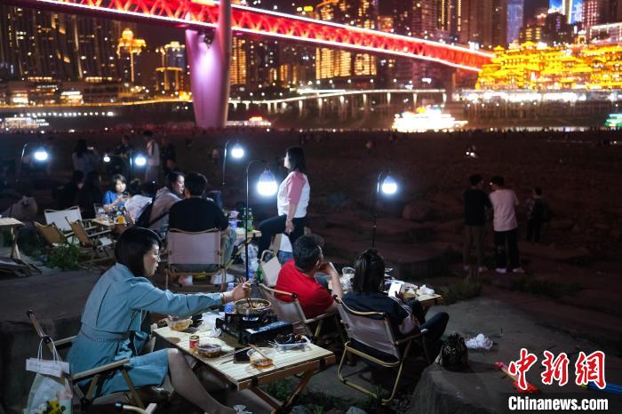 游客在江北嘴江滩公园吃火锅，观赏洪崖洞夜景。　何蓬磊 摄