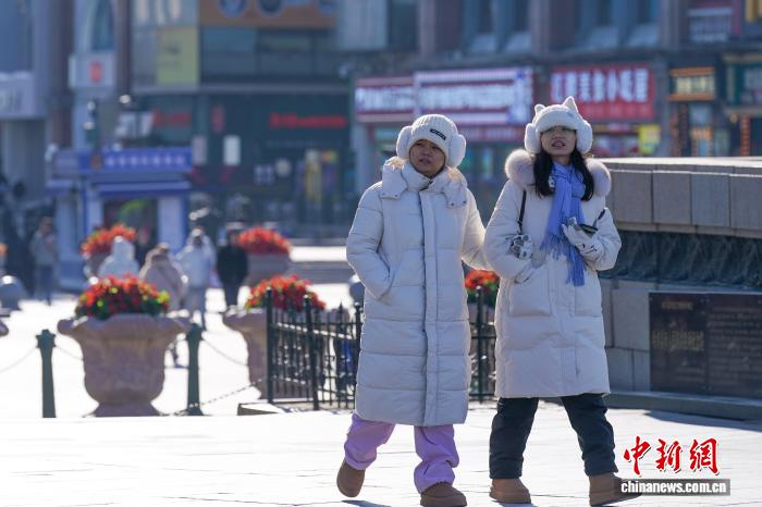 黑龙江哈尔滨气温持续走低 市民添衣出行