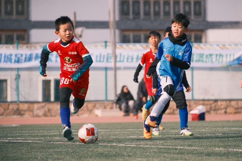2026年1月1日，在山东省青岛市城阳区夏庄街道山色峪乡村振兴齐鲁样板省级片区举办的足球邀请赛上，足球小将在带球进攻。
