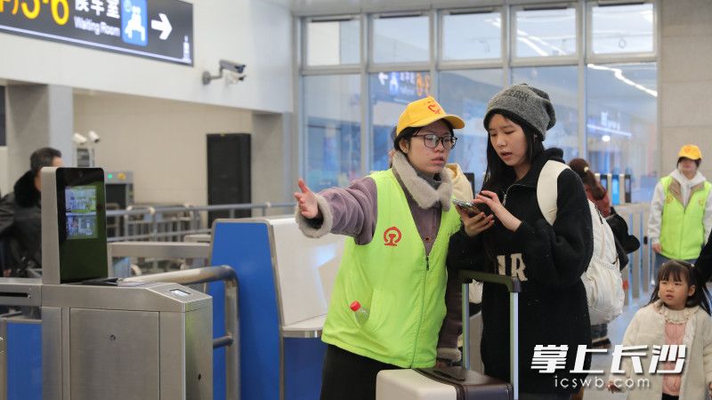 组图丨春运首日志愿者上岗暖旅途,长沙火车站服务提质迎客流高峰 志愿者指引旅客入站。