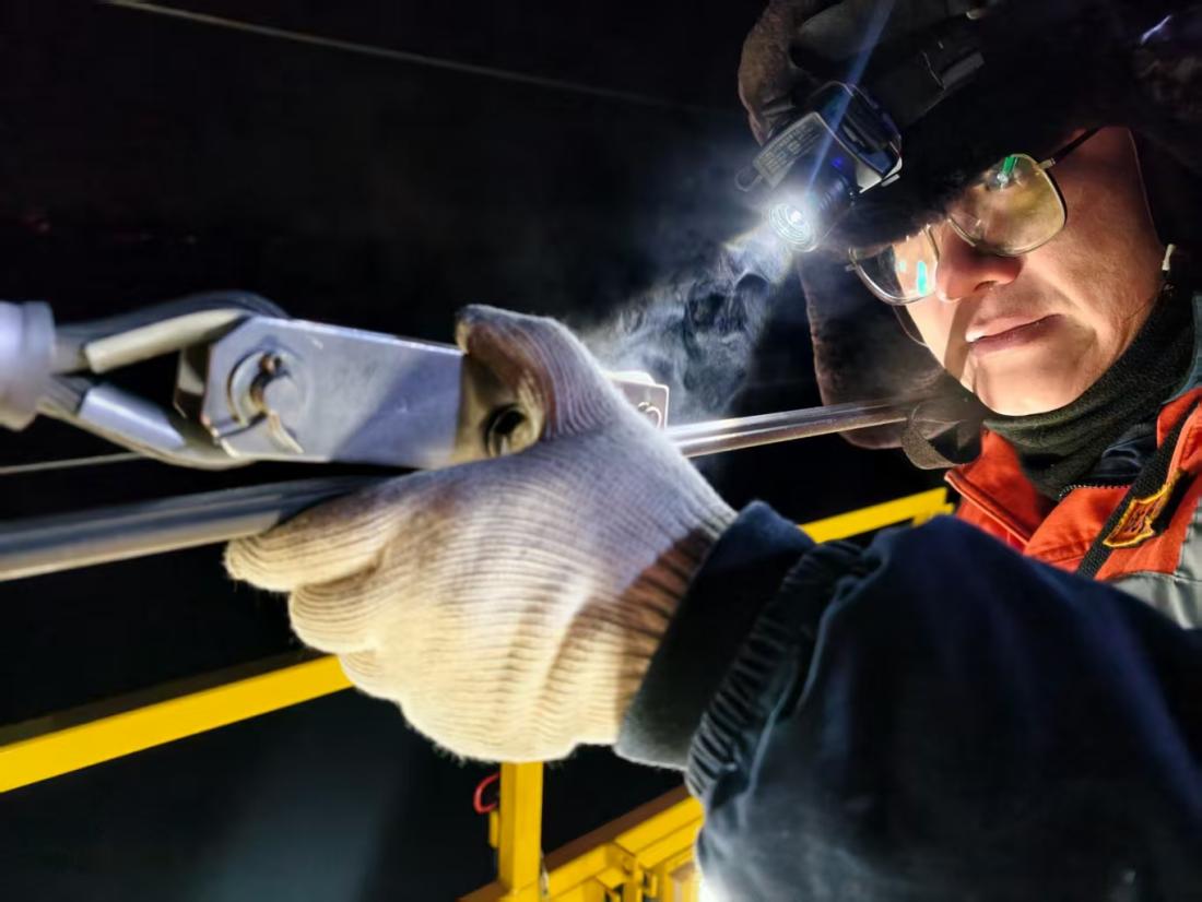 接触网工李强正在调整接触线中心锚结。人民网记者 王斯文摄