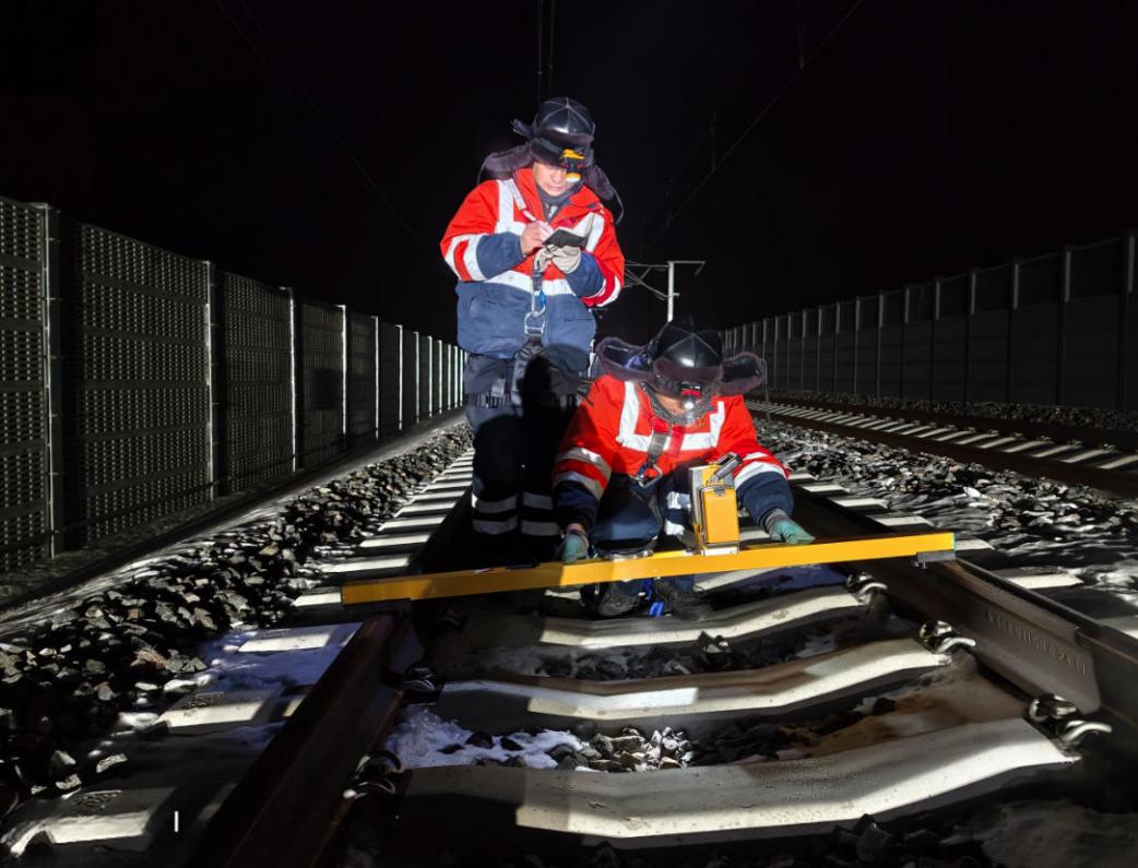 李强、苗畅对接触线高度、拉出值进行测量。人民网记者 王斯文摄