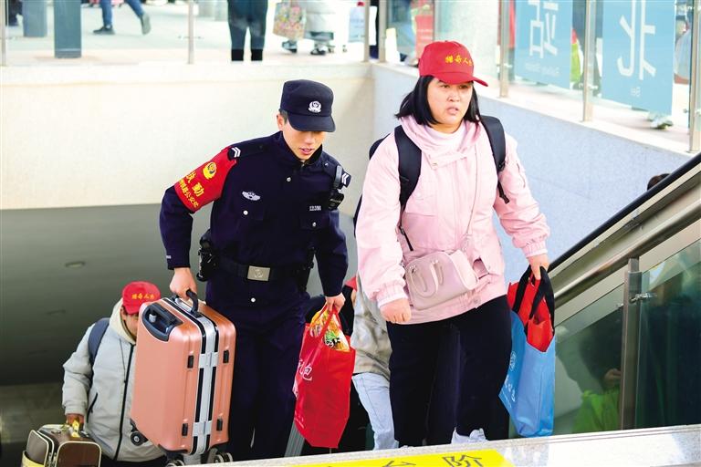 图为民警帮助务工人员搬运行李。