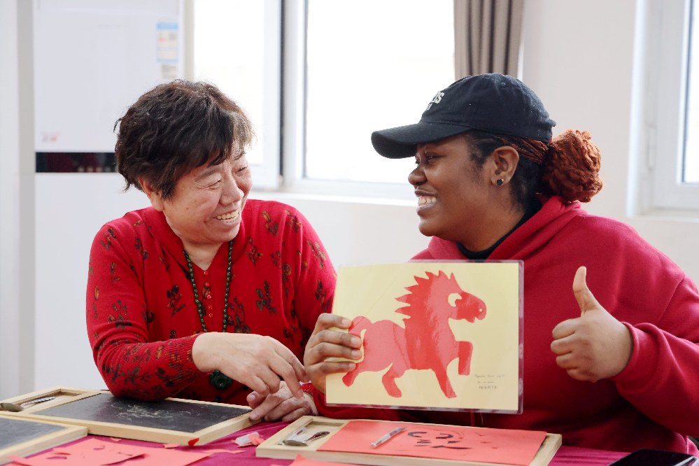 社区居民与留学生一起体验刻纸的快乐。王杰摄