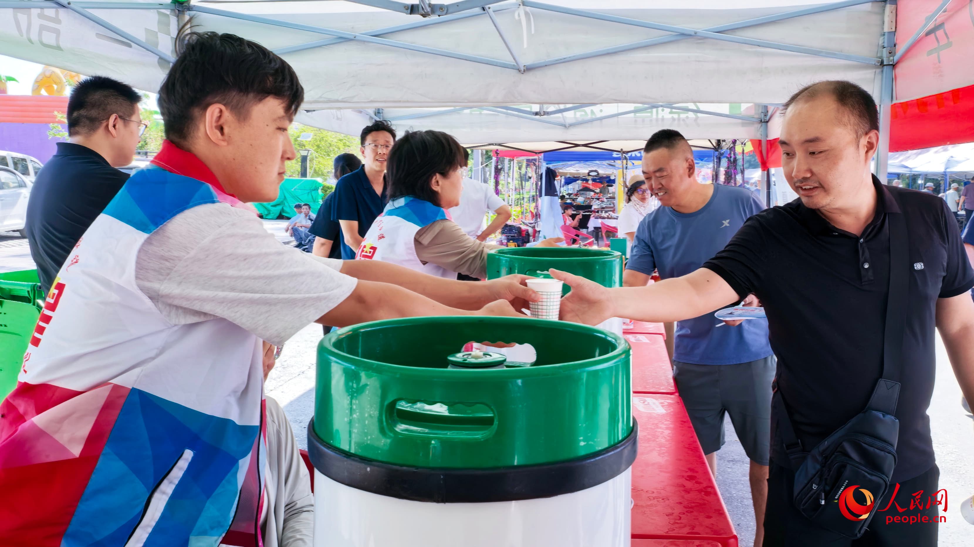 “嗨啤乌苏·乐享盛夏”2026新疆塔城乌苏啤酒节开幕 乌苏市免费啤酒品饮点之一。人民网 娜地拉摄