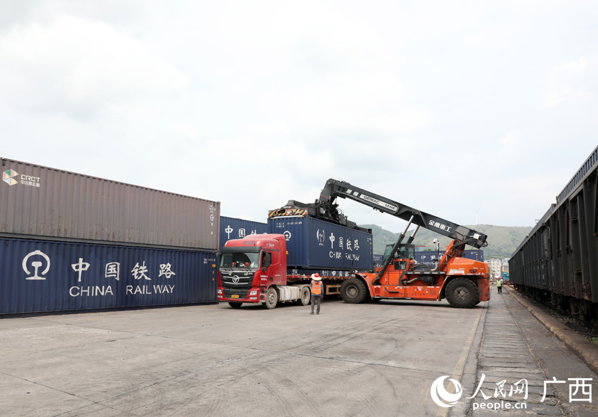 平陆运河首批“铁江海”联运货物从南宁发出 图为六景铁路货场内作业人员正在进行集装箱装运作业。