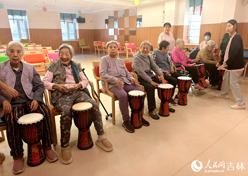 多点赋能筑暖巢 长春勾勒银发幸福图景 亲亲园养老护理康复中心,老人坐在一起学敲鼓。人民网记者 关思聪摄