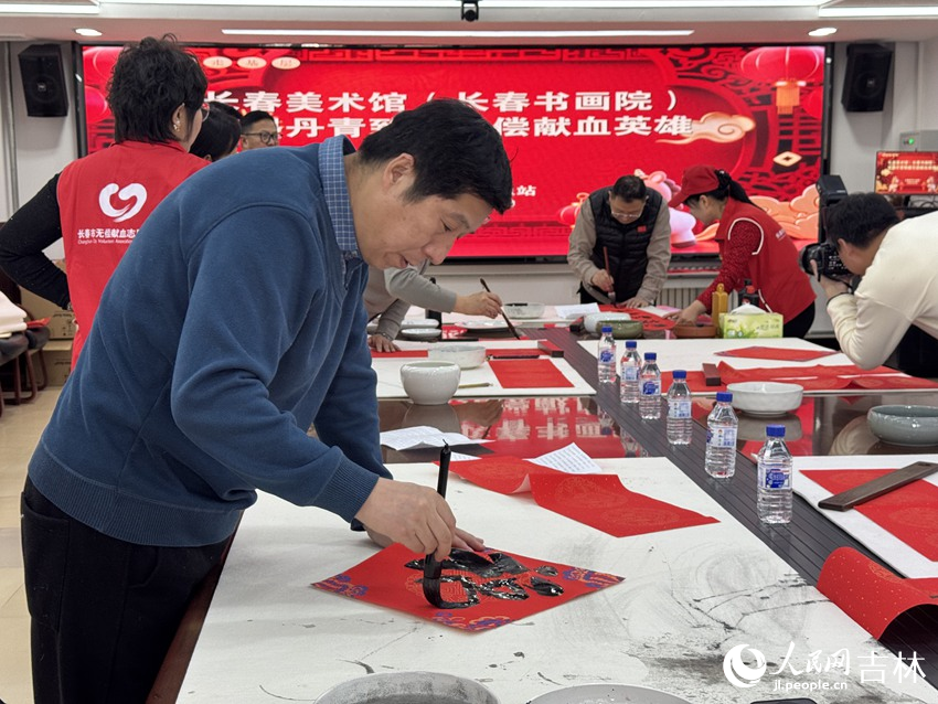 来自长春美术馆（长春书画院）的书画家们以春联与“福”字为载体，向无偿献血者们表达敬意与新春祝福。人民网记者 李思玥摄