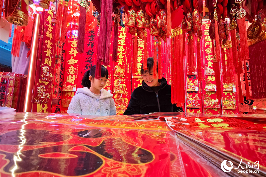 市民在年货店内精心挑选新春装饰。 人民网 涂诗轩摄