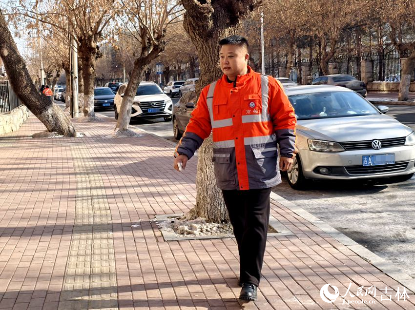 姜丽君在南关区平泉路巡查卫生情况时，随手捡起垃圾扔到垃圾箱里。人民网记者 关思聪摄